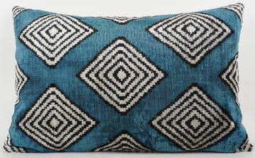 Blue pillow with black diamond pattern on a white background